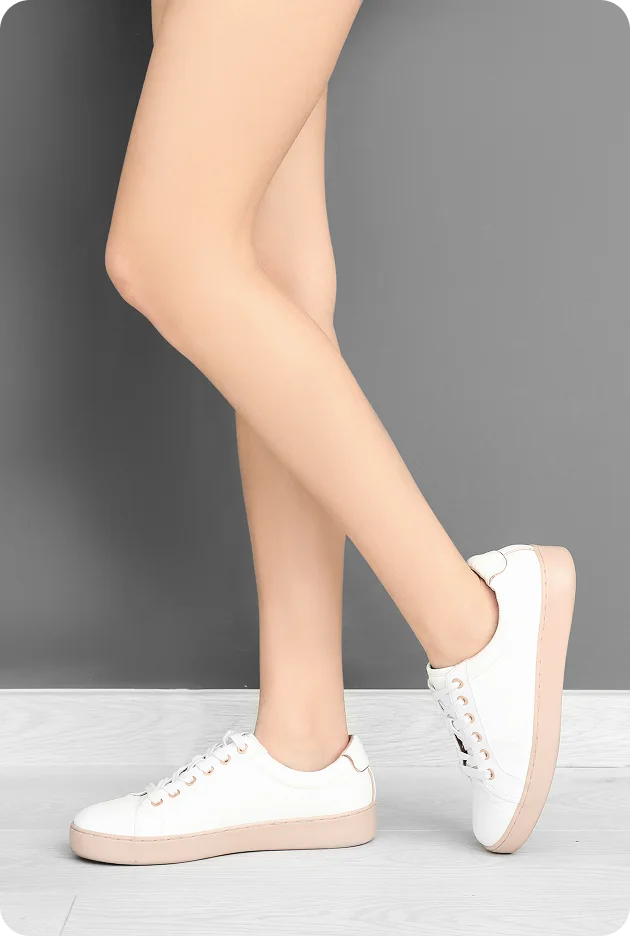 Stylish white platform sneakers on model against a gray background